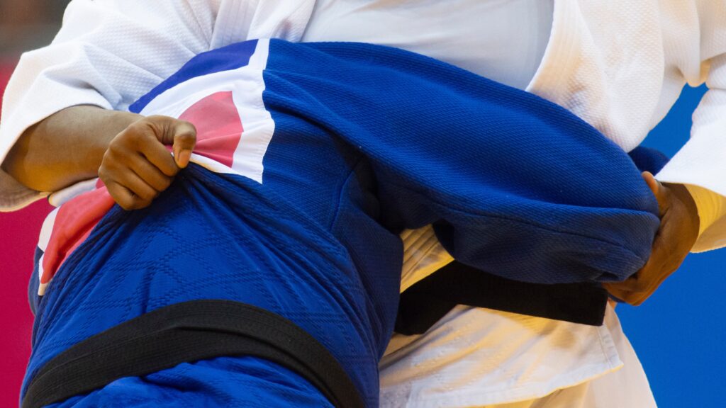 Two judo fighters in white and blue uniform. Professional sport concept